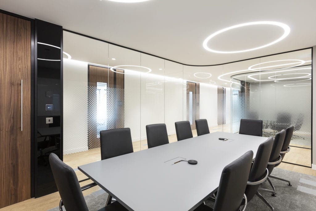 Workplace meeting room with circular track lighting on ceiling.